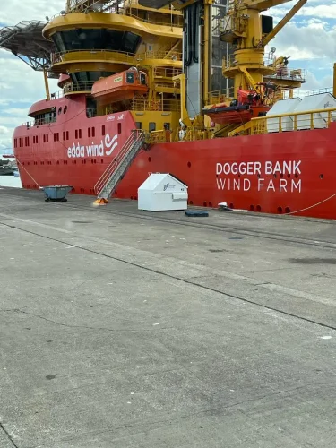 A white JBM Environmental Services FEL waiting to be loaded on a ship to dogger bank